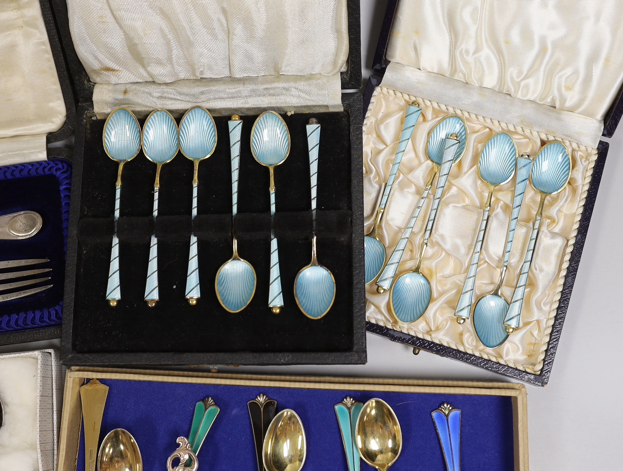 Two sets of eight Norwegian 925S and polychrome enamelled coffee spoons, by David Andersen, one other cased set of six Norwegian 925 and enamelled coffee spoons, a similar spoon and fork, a set of twelve Danish sterling